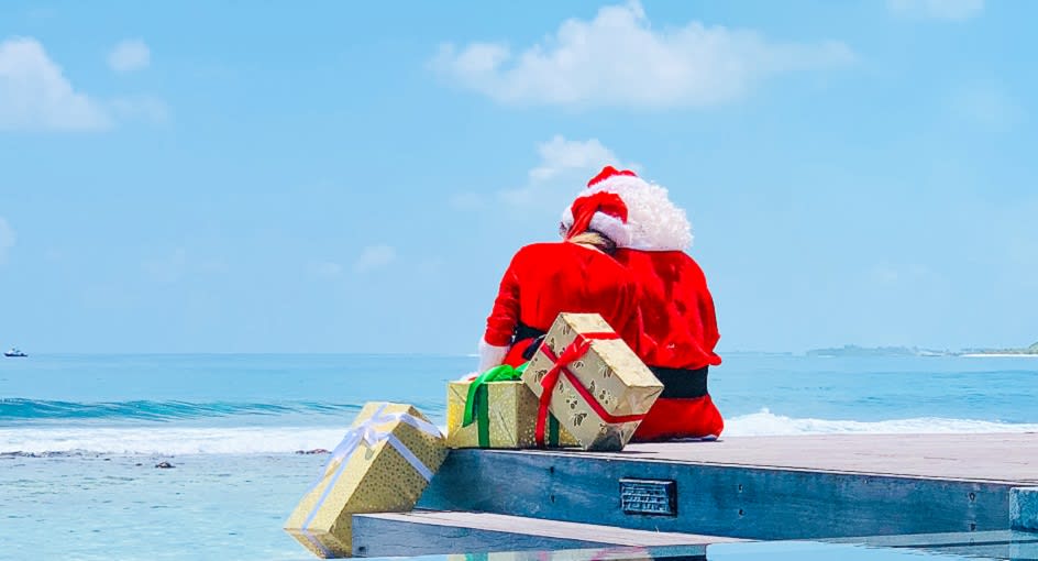 Santa with Christmas gifts enjoying the ocean views at Anantara Veli Maldives Resort