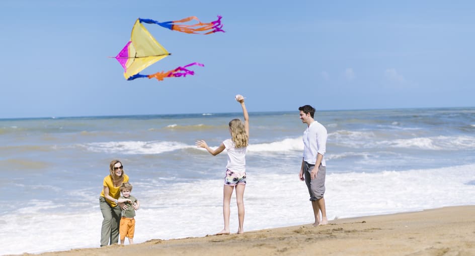 Family flying a kite on the beach