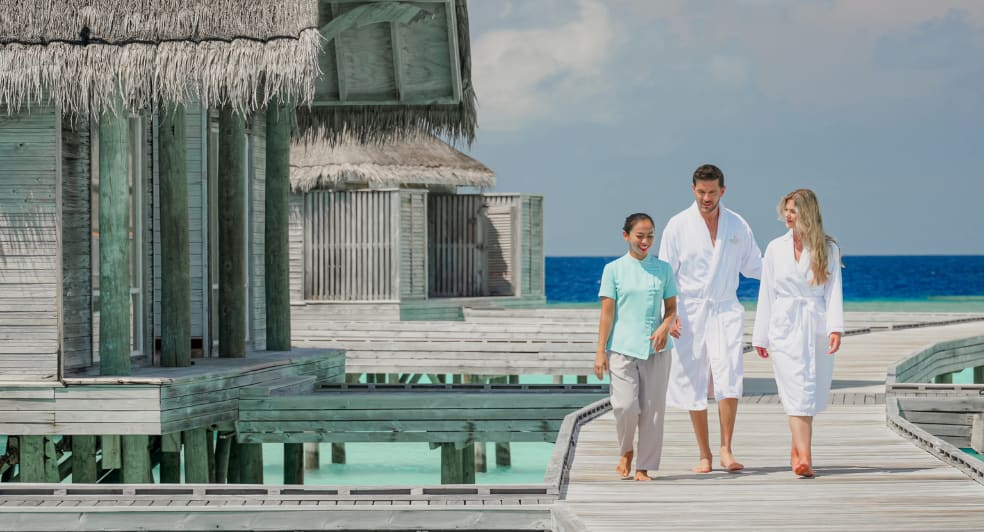 Guest is walking to Spa at Anantara Kihavah Maldives