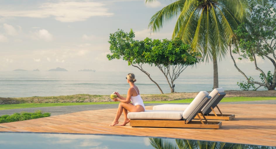 woman sits by the pool