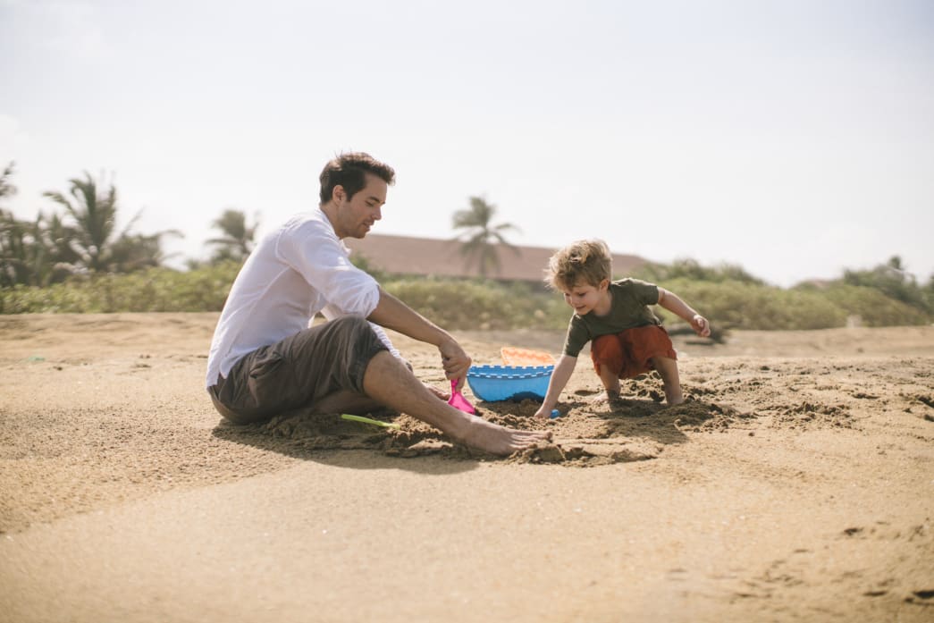 A father and son playing at the beach.