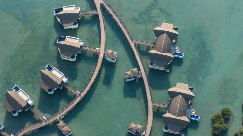 An aerial view of overwater villas at Anantara Mina Al Arab Ras Al Khaimah Resort.