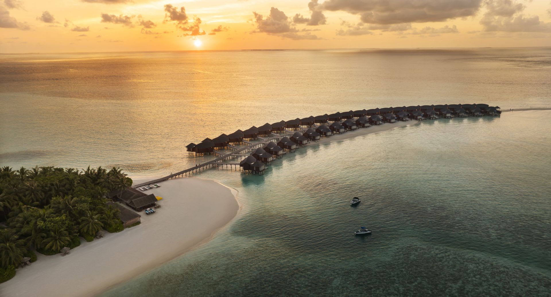 Sunset aerial view of the Over Water Villas at Anantara Dhigu Maldives Resort