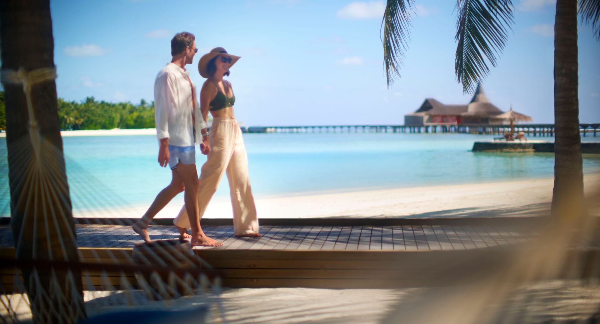 Couple walking on the beach at Anantara Veli Maldives Resort