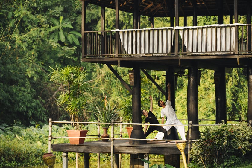A pair of instructor and student partake in a yoga class.
