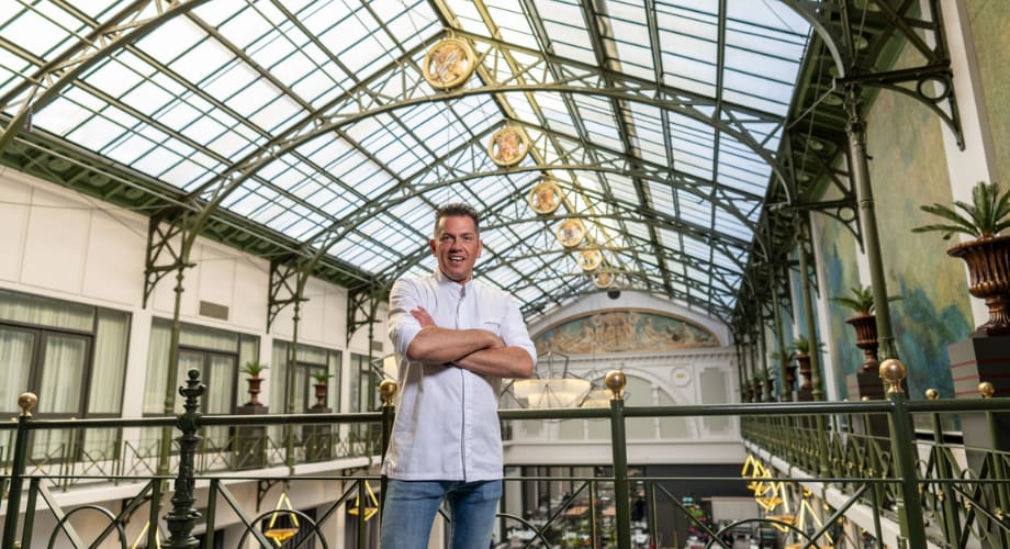 Chef Jacob Jan Boerma on a balcony under a glass ceiling at Anantara hotel Amsterdam. 