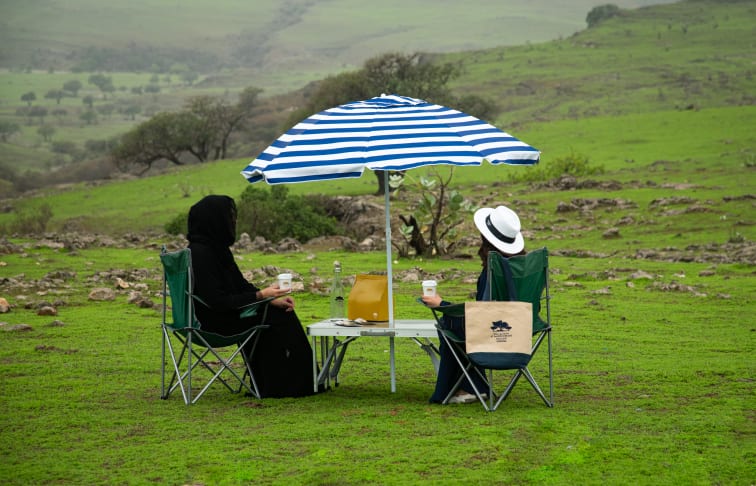 Two people partaking in a Khareef picnic experience.