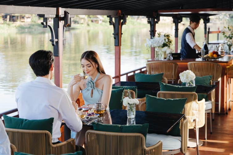 A couple having food and drinks during daytime on the JAO Ping River Cruise.