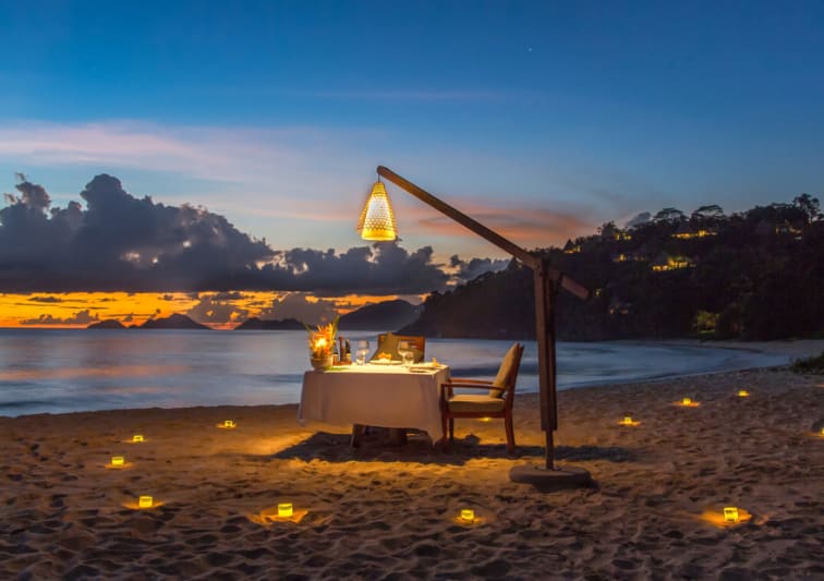 Romantic private dinner setup on beach at sunset