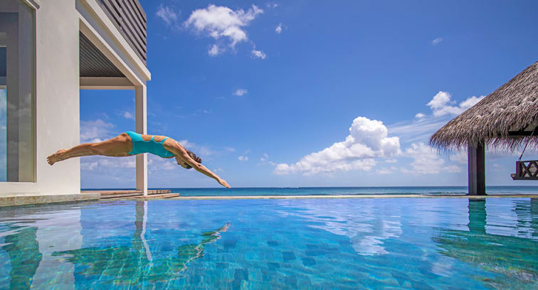 Woman enjoying pool in private ocean house at Naladhu Private Island Maldives