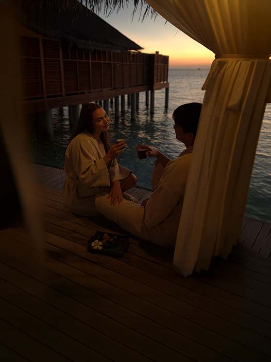 Couple enjoying a romantic evening beach dinner at Anantara Dhigu Maldives Resort