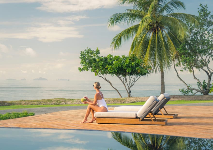 woman sits by the pool