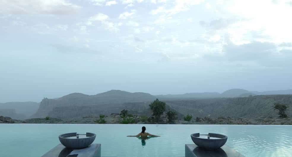 Swimming Pool with Panoramic View of Green Mountains in Oman