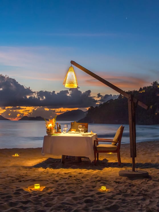 Romantic private dinner setup on beach at sunset