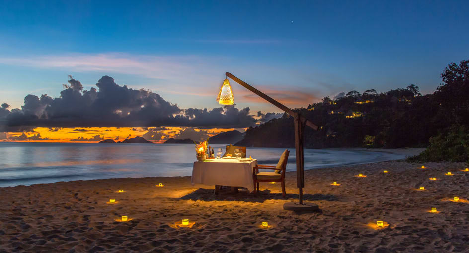 Romantic private dinner setup on beach at sunset